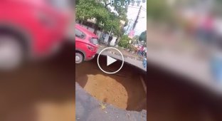 The driver managed to escape when a huge crater appeared under his car.