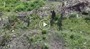 A dark-skinned mercenary of the Russian army fights off a Ukrainian drone with a stick