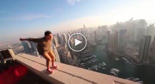 Экстремал Олег Шерстяченко выполняет опасные трюки на крыше небоскреба