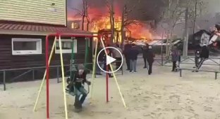 Невозмутимый мальчик на качелях рядом с пожаром в Ноябрьске