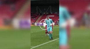 Football in Scotland: goalkeeper runs across the field with a shovel