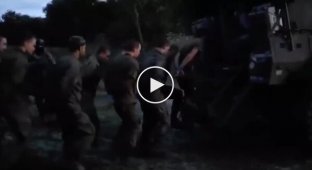 Soldiers load captured Russians in the Kursk region into an armored vehicle