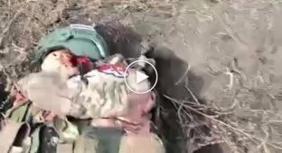 A Ukrainian soldier removes chevrons from a deceased Russian soldier in the Avdeevka area
