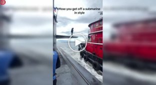 Чоловік крокує з підводного човна на інший корабель у відкритому морі