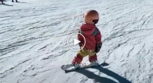 Маленькая девочка очень круто катается на сноуборде