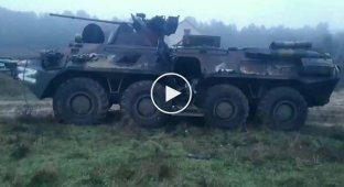 An occupier shows a destroyed armored personnel carrier and a tank in Krynki in the Kherson region