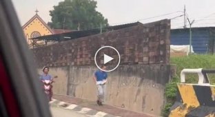У Малайзії жінка на мотоциклі і з палицею в руках змушує бігати свого повного сина