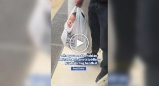 У Китаї чоловік несе дитину в пакеті