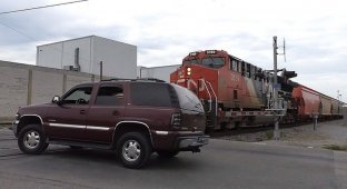 Поезд против Chevrolet Tahoe: водитель не стал дожидаться, пока поднимется шлагбаум (2 фото + 1 видео)