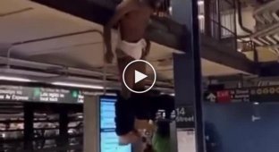 A black man hangs his pants on the New York subway
