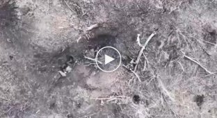 A Russian soldier throws a bomb fired at him from a Ukrainian drone towards his comrade