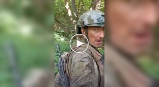 An occupier films his one-legged comrade crawling on all fours through the forest