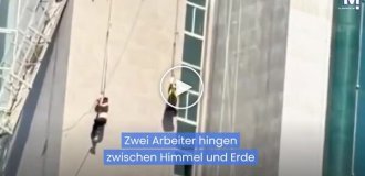 Two workers hung on the facade of a building after cables snapped