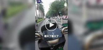 В Китае курьер спас водителя, потушив загоревшийся электроскутер