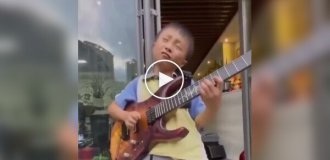 Мальчик великолепно играет на гитаре