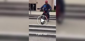 A father-cyclist teaches his one-year-old son to ride a bike