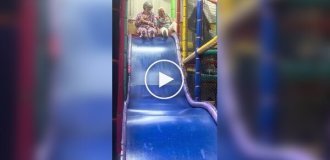 Cheerful grandmothers ride on a children's slide