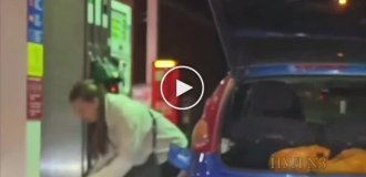 На заправке девушка набирала бензин в пластиковые пакеты