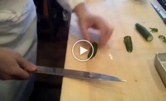 Мастер шеф нарезает огурец в суши бар