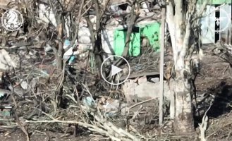 Two invaders enter a dilapidated garage and a Ukrainian kamikaze drone flies towards them through the open door.