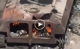 Охоплений полум'ям окупант марно намагається вибратися з бронемашини, що горить.