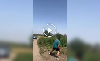 Житель РФ камнем пытается попасть в беспилотник, летящий низко над землей