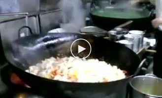 Китайский шеф-повар жарит большую порцию мяса с овощами на воке