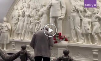 Пожилой россиянин крестится и кланяется перед памятником Сталину в московском метро