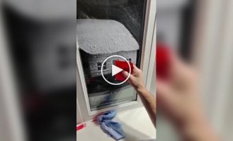 A guy paints fairytale pictures with artificial snow on windows