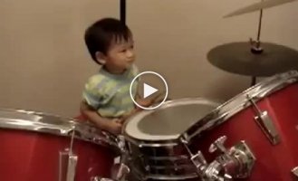 Годовалый ребенок играет на барабанах