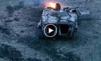 A Ukrainian drone operator watches the crew of a Russian BMP-1 sunbathe under a damaged and burning vehicle
