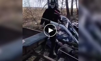 Russian 200th lie in black bags on the edge of a grove