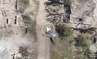 The body of an occupier, thrown out of an armored vehicle by an explosion after the detonation of ammunition, burns on the road