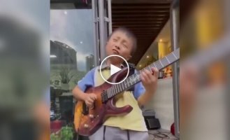 A boy plays the guitar brilliantly