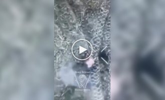 Оккупант, запутавшийся в заградительной сетке, горит после сброса с украинского БПЛА