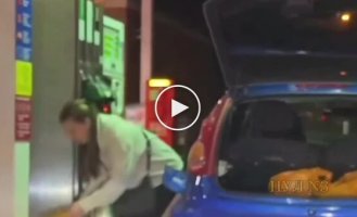 A girl was filling plastic bags with gas at a gas station