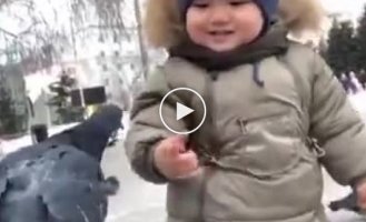 A child froze in a funny pose when meeting a pigeon