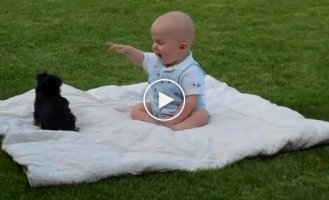 Малыш отдыхал на траве вместе с маленьким щенком