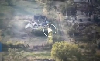 An occupier with his hands raised walks along a broken street in Volchansk