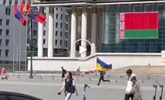 A policeman chases a man with a Ukrainian flag who ran into the central square of Ulaanbaatar during Lukashenko's visit to Mongolia