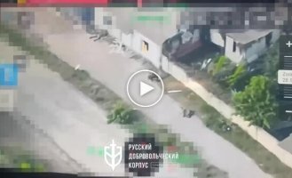 Liquidated occupiers lie under a fence on the street in Volchansk