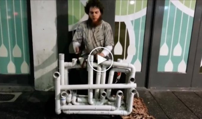 Талантливый уличный музыкант играет на водопроводных трубах