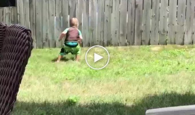 Мальчик и собака играют в мяч через забор