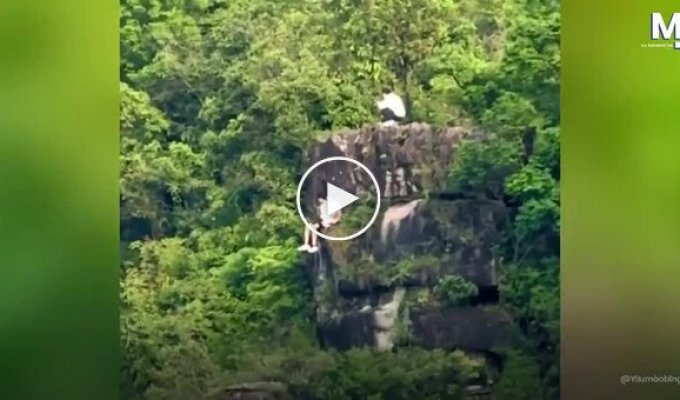 Туристи розташувалися на краю прямовисної скелі