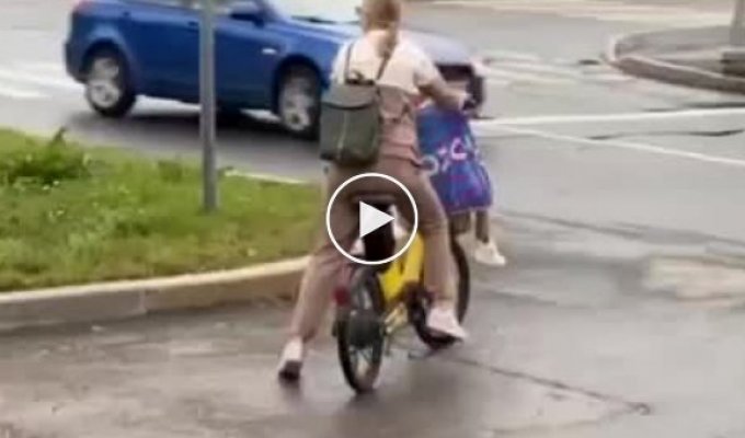 The mother put the child on the front of the bicycle and rode out onto the road.