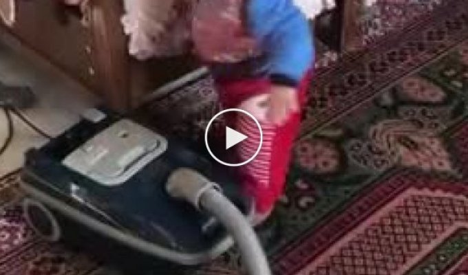 Маленький помошник помогает пылесосить квартиру