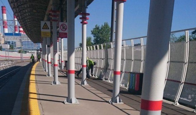 Бесстрашные коммунальщики красят решетку на станции (2 фото)