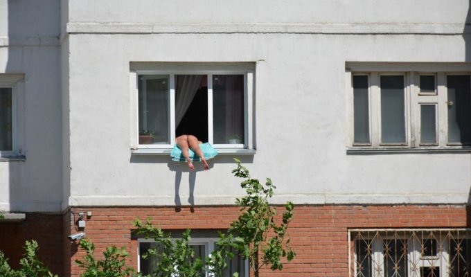 В Новосибирске жалуются на голую женщину, загорающую в окне второго этажа (7 фото)