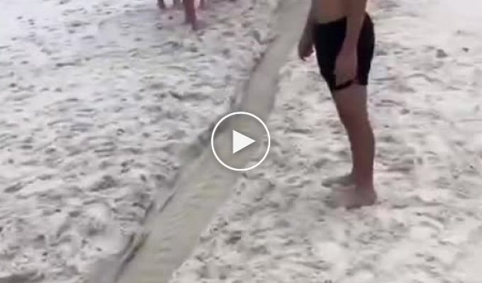 A man dug a canal on the beach, connecting two bodies of water