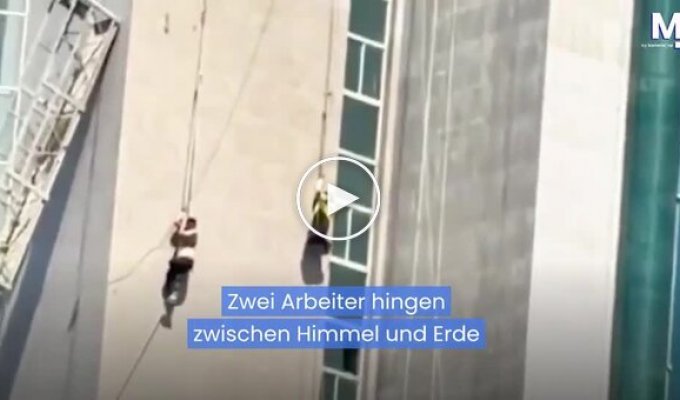 Two workers hung on the facade of a building after cables snapped